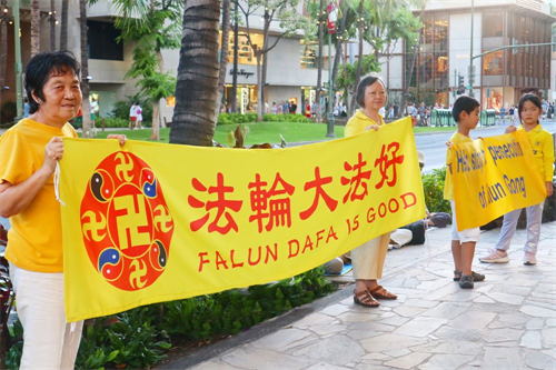 '图1:夏威夷法轮功学员在当地著名景点威基基海滩附近的商业步行街上打横幅'