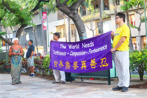'图3:法轮功学员打出横幅“世界需要真善忍”,过往民众在驻足观看。'