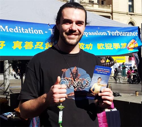 '图6:托马斯·詹金斯(Thomas Jenkins)手举制止活摘的真相资料赞扬法轮功:真棒!'