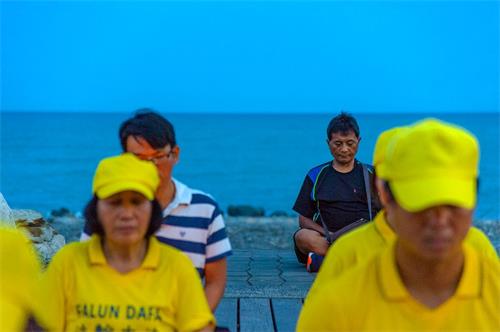 '图7:台东法轮功反迫害烛光悼念,路过民众主动与法轮功坐在一起,表达支持。'