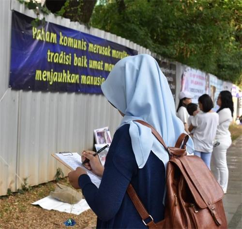 '图4~5:雅加达中使馆前,法轮功学员的真相横幅吸引过往车辆、行人的关注,民众纷纷签名支持反迫害。'