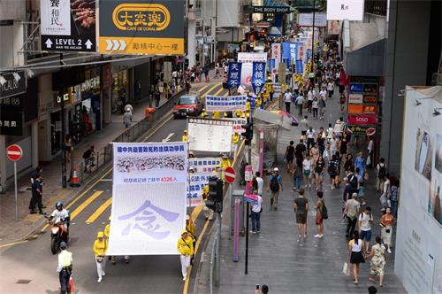 图9:游行队伍展示大幡,悼念被中共迫害致死的法轮功学员。