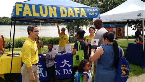 '图1:民众驻足法轮功学员的真相展位'