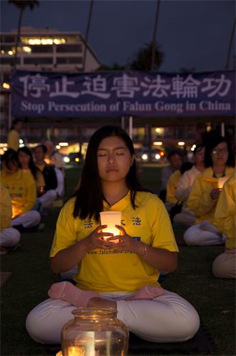 '图9~11:法轮功学员们点起蜡烛,悼念在二十年迫害中失去生命的大陆法轮功修炼者'
