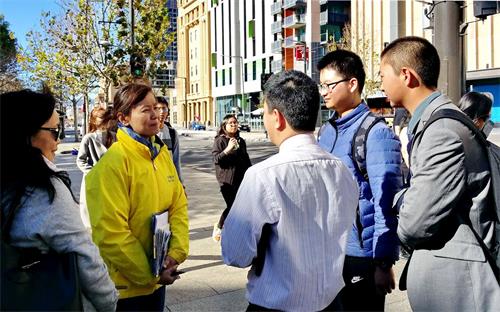 '图8:华人驻足听法轮功学员讲真相'