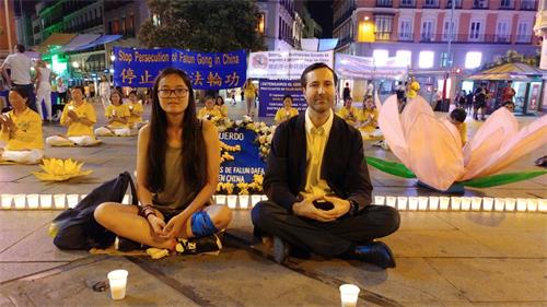 '图2:1:2019年7月19日,在马德里Callao广场,Marta小姐 和Alberto先生主动留下来和法轮功学员一起,席地而坐,烛光守夜。左边是 Marta, 右边是Alberto'