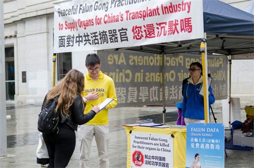 '图2:民众在呼吁澳洲政府敦促中共停止迫害的请愿书上签名。'