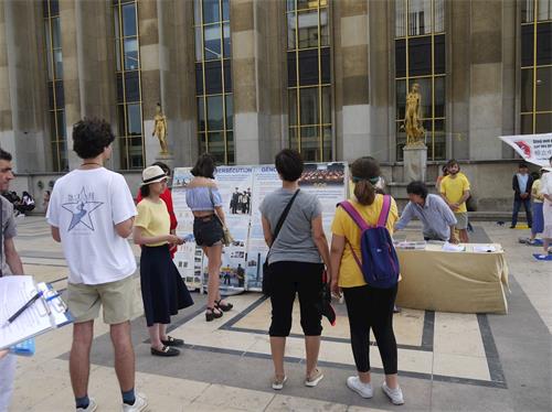 '图3~4:游人观看法轮功展板,了解真相'