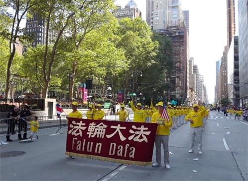 '图1~2:法轮功功法演示队伍在游行中展示功法。'