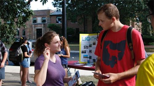 '图4:一位学生(右)认真倾听大法真相'