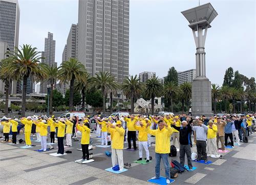 '图1:法轮功学员在旧金山渡轮大厦前集体炼功,向民众展示祥和优美的功法。'