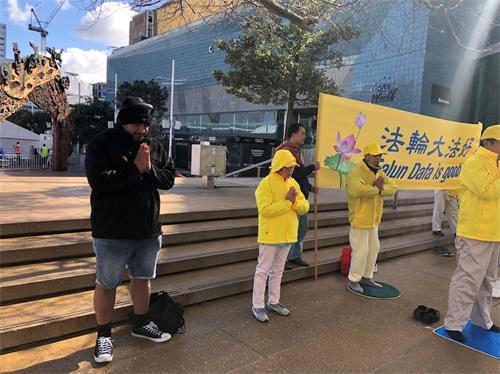 '图8:克里斯加入法轮功学员炼功,表示支持反迫害。'