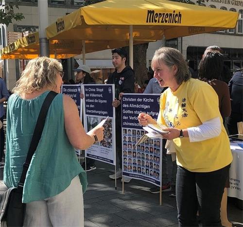 '图2~5:法轮功学员们的真相点吸引了很多民众的注意'