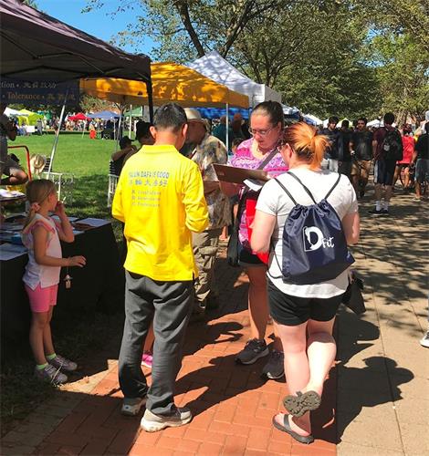 '图3~4:在德拉华州纽瓦克社区日上,法轮功学员向民众介绍法轮功并讲真相。'