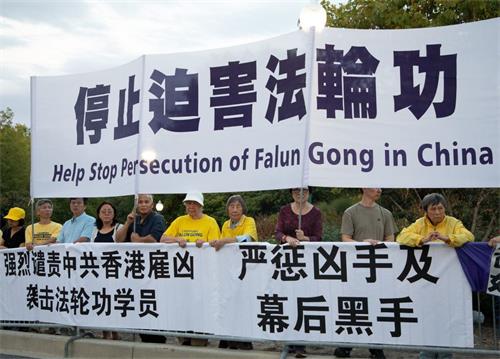 '图1:二零一九年九月二十六日晚,美国首都华盛顿的部份法轮功学员在中共驻美使馆外集会,要求立即停止迫害法轮功,并强烈谴责中共在香港雇凶袭击法轮功学员廖秋兰。'