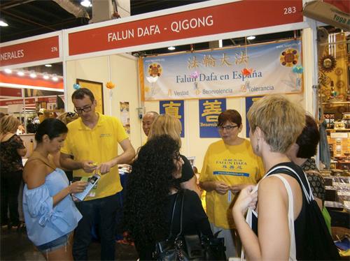 '图1~2:法轮功学员参加西班牙瓦伦西亚健康博览会,介绍功法。'
