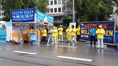 '图4:法轮功学员在雨中坚持炼功'