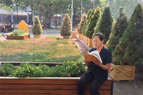 '图:小玉正在阅读法轮大法创始人李洪志大师的专著《转法轮》'