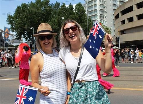 '图11:墨尔本理工大学讲师凯莉(Kerry,左)和大学生賈茲明(Jazmyn)赞叹法轮大法的队伍不同凡响。'