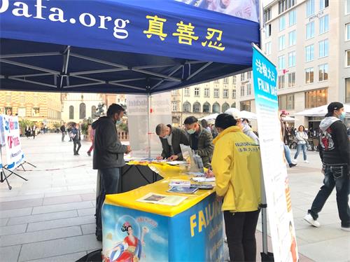 '图5:一群年轻人在展台前签名,制止中共活摘法轮功学员器官。'