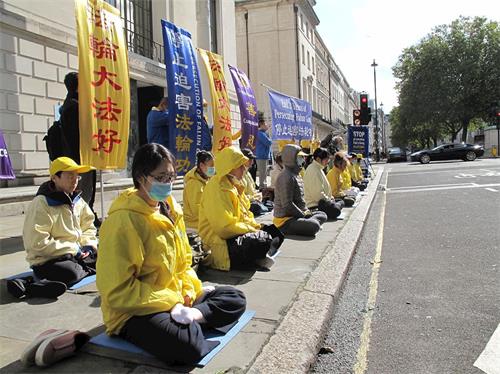 '图1~2:二零二零年十月一日,英国法轮功学员在伦敦中使馆前举行反迫害活动,吸引过往民众关注,支持法轮功反迫害。'