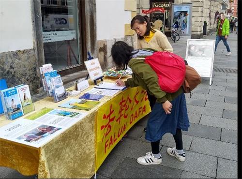 '图5:一位来自台湾了解真相的女士来到展位前签字并表达她对法轮功的支持'
