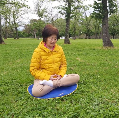 '图2:陈贤凤女士在炼法轮大法第五套功法——神通加持法。'