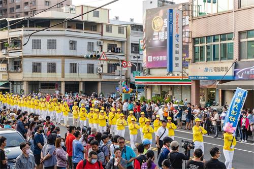 '图6~7:祥和优美的法轮功炼功队伍,经过主席台时,很多贵宾挥手致意,有不少民众用手机、相机拍照。也有民众询问到哪里可以学炼。'