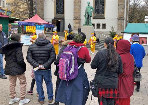 '图4:腰鼓队的表演吸引不少过往行人驻足观看'