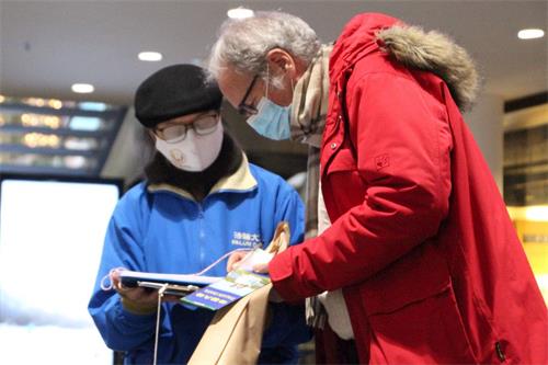 '图9~12:在阿劳火车站的大厅里,人们了解了法轮功真相后签名支持法轮功'