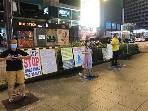 图2:马来西亚法轮功学员在吉隆坡市中心挂展板、炼功,向民众讲真相。