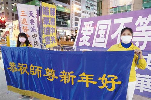 '图4:在旺角真相点讲真相的法轮功学员恭祝李洪志先生新年快乐。'