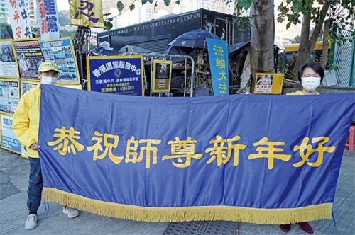 '图5:在黄大仙真相点讲真相的法轮功学员恭祝李洪志先生新年好。'