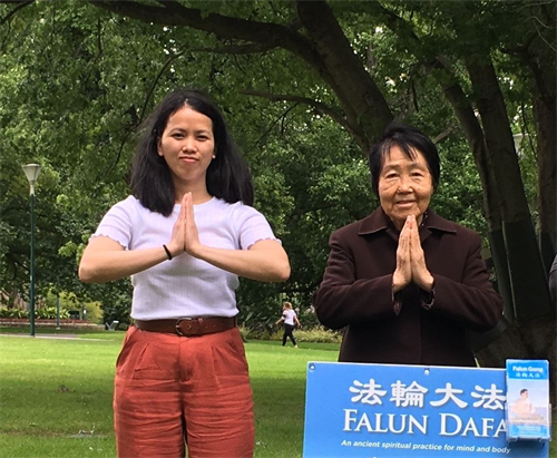 '图2:今年八十四岁的学员邬大姐(右)和修炼数月的新学员、越南留学生翠音(Trang,左)恭祝师尊新年好。'