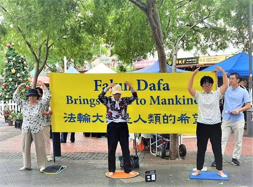 '图13:十二月十三日法轮功学员在悉尼堪普西(Campsie)主街展横幅和演示功法'