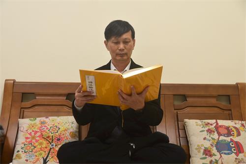 '图2:廖伟辰在读法轮大法书籍,表示他已拥有生命中最珍贵的财富。'