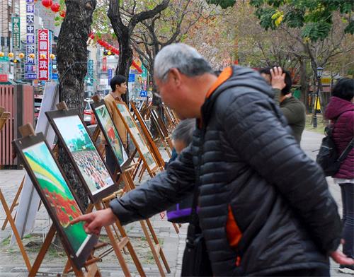 '图5:民众认真观看法轮功真相展板'