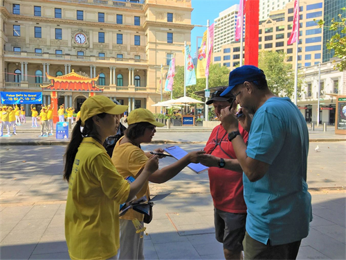 '图2~7:人们驻足了解法轮功真相,纷纷签署帮助停止迫害的请愿书'