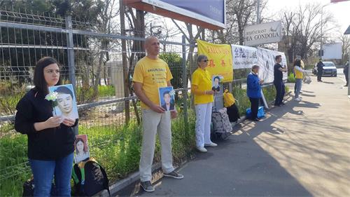 '图:罗马尼亚法轮功学员们在中使馆前举行和平抗议活动。'
