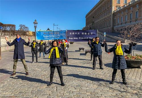 '图3:法轮功学员伴随着炼功音乐向路人演示法轮功的五套功法。'