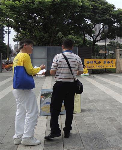 '图10:中正公园埔子图书馆炼功点学员向民众讲真相。'