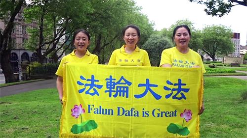 '图1:这几位是住在西北英格兰的法轮功学员,她们拉开“法轮大法好”横幅,恭祝师父生日快乐,庆祝世界法轮大法日!'
