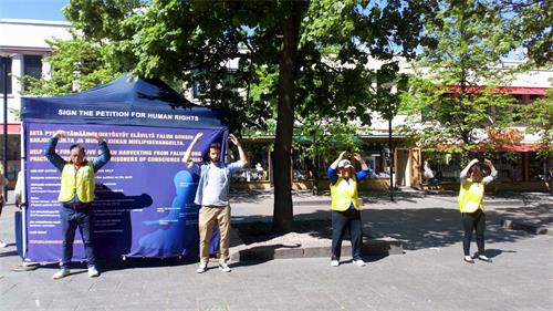 '图1:部份法轮功学员在甘比购物中心广场上炼功。'