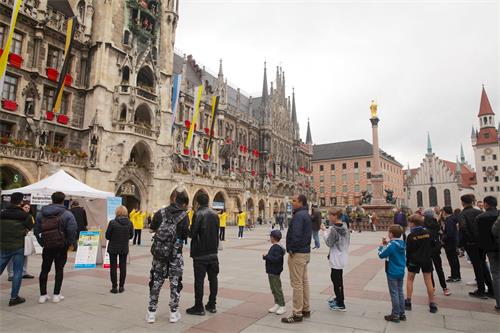 '图1:二零二零年六月十日,德国慕尼黑玛琳广场(Marienplatz)上,民众观看法轮功学员展示功法演示。'