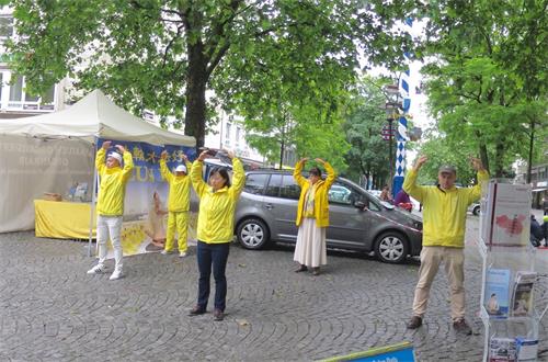 '图4~5:德国慕尼黑法轮功学员在红十字广场(Rotkreuzplatz)展示功法演示。'