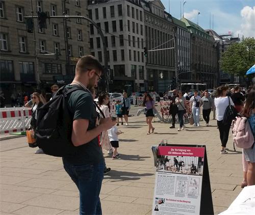 '图3~13:汉堡民众了解法轮大法以及中共对法轮功学员的迫害。他们在征签表上留下签名,支持法轮功学员的反迫害活动。'