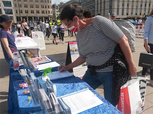 '图16:民众布里塔签名支持法轮功学员反迫害'