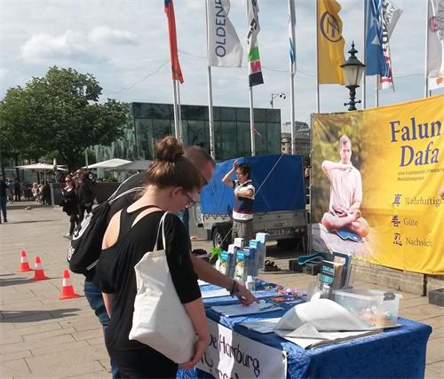 '图18:这对夫妻看过真相展板上的照片和信息后,在征签表上留下签名。'