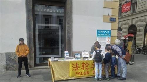 '图4:人们驻足法轮功学员的真相展台'