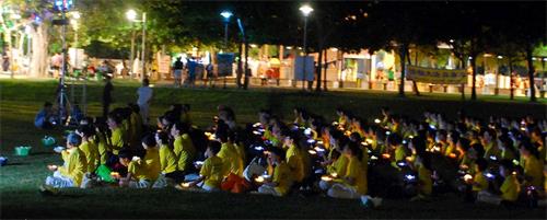 '图9~10:两百多位学员手心捧着点点光明,场面肃穆感人。'